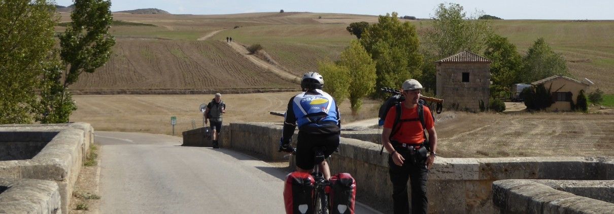Ciclista y peregrinos en Camino de Santiago.